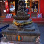 2014.12.09 Kathmandu 89 Kathesimbhu Stupa Bright buddha and shop ResizeBy Donna Yates CC BY-NC-SA